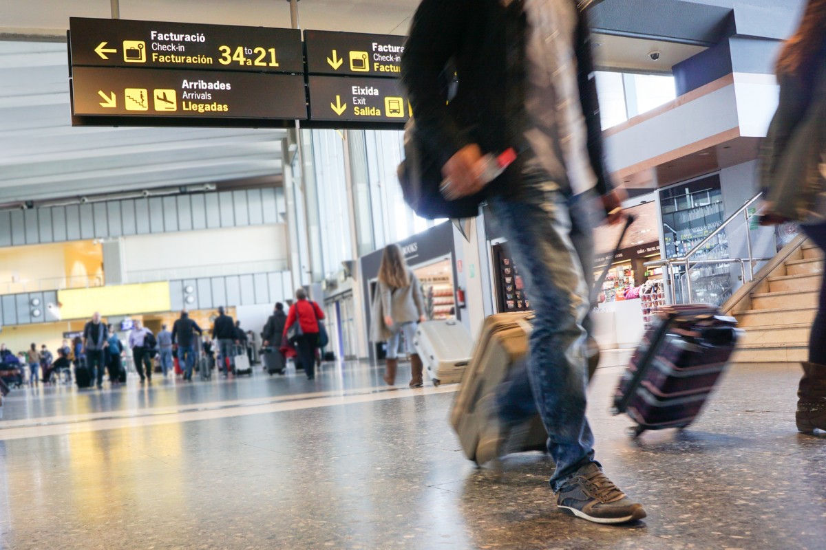 personas caminando con maletas en aeropuerto