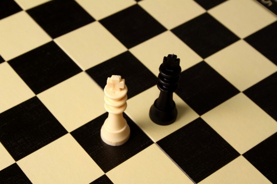 tablero de ajedrez en el que aparecen dos fichas; una negra y otra blanca. Cada una se halla en una casilla de su color opuesto.