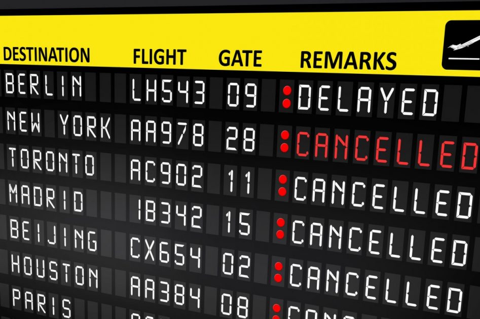 panel informativo negro de aeropuerto con letras mayúsculas en rojo por cancelación.