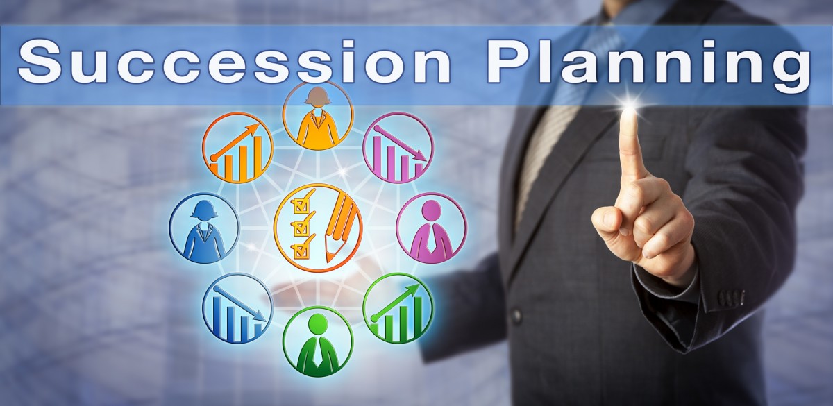 un hombre señala las palabras de succession planning mientras sostiene iconos digitales diversos